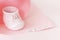 Top view of beautiful porcelain mug pink baby shoe shape and My girl letters in paper swirl on pastel color background