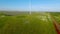 Top view of beautiful railway on background of green field. Shot. Wind farm near beautiful railway in green field