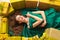 Top view of beautiful slender fashion woman in trendy green dress lying with golden boxes with gifts. cheerful girl