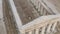 Top view of beautiful tall white columns and small figures of bride in white wedding dress and groom walking along them