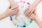 Top view of beautiful woman`s hands with collection of color nail polish samples on white background