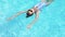 Top view beautiful woman swiming on back in swimming pool At Luxury hotel spa