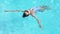 Top view beautiful woman swiming on back in swimming pool At Luxury hotel spa