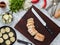 Top view of a beautiful wooden board with a large knife and chopped bread