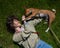 Top view of beautiful young woman and african basenji dog lying on green grass.