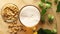 Top view of beer with foam and salty peanuts and on wooden table