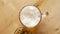 Top view of beer with foam and salty peanuts and on wooden table