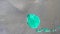Top view of big turquoise stain on grey metal background holding stil. Big drop of bright teal paint with glowing
