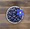 Top view. Bilberres and blue flower. Ripe blueberries with copy space for text. Ripe and tasty blueberries. Blueberries in a white