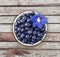 Top view. Bilberres and blue flower. Ripe blueberries with copy space for text. Ripe and tasty blueberries. Blueberries in a white