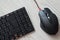 Top view of black computer mouse and keyboard with English and Russian letters