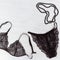 Top view Black Lace lingerie set and Black beads on white wood. Beautiful womens underwear