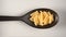 TOP VIEW: Black spoon with spiral pasta fusilli