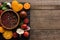 Top view of black tray with pepper in bowl, chilli pepper, sliced tomatoes and garlic on wooden table.