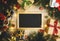 Top View of Blackboard Surrounded By Christmas Gifts Ornament. C