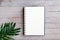Top view of blank notebook and green plant on wooden pallet