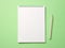 Top view blank paper Notebook and pencil. Desktop mock up, Flat lay of green working table background with office