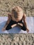Top view of blond girl meditation in lotus pose on sea shore at sunrise