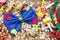 Top view of a blue bowtie and colorful party decorations on a wooden table