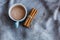 top view blue mug of cocoa and a bunch of cinnamon sticks