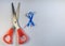 Top view of blue ribbon and scissors for awareness campaigns on male health and prostate cancer