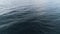 Top view of blue sea ripples. Shot. Background of water surface with smooth waves and ripples. Movement of blue surface