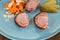 Top view of a blueish plate with sliced roast pork, vegetables a