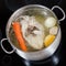 Top view of boiling chicken broth in pan