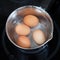 Top view of boiling chicken eggs in metal pot