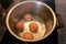 Top view of boiling organic eggs in metal pot into saucepan on electric stove in kitchen. Four chicken eggs in pot.