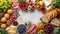 Top view a bordered background with a continental breakfast with variety of fruits, berries, cheese, cold cuts and bread with