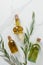 top view of bottles of three bottles of olive oil and twigs on marble