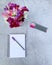 Top view of a bouquet of sweet peas on a rough surface with colorful pens and a notepad on it