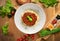 Top view of a bowl of bolognese pasta on a wooden tabletop.