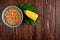 top view of bowl full of dried corn kernel with cut cooked corn and spinach on wooden background with copy space