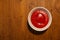 Top view of bowl full of tomato sauce on wooden background