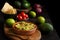 Top view of bowl with guacamole on dark table with tomatoes, avocados, limes and nachos