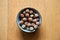 Top view of a bowl of hazelnuts on a wooden table in a blurred background