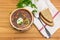 Top view of bowl with meat solyanka, spoon, bread, greens