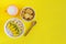 Top view on bowl of oatmeal decorated with banana, kiwi, mango, coconut chips and bowl of homemade cookies with cup of milk.