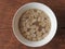 Top view of a bowl of peanut soup isolated on wooden background.