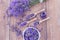 Top view of a bowl and wooden spoons with fresh lavender flowers, lavender essential oil and a bouquet of lavender