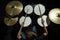 Top view of a boy learning to play the drums in the studio on a black background. A student of a music school.