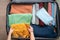 Top view of a boy`s hands packing things into a suitcase. The boy is going on vacation after a long quarantine. The joy of the