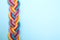 Top view of braided colorful ropes on blue background, space for text. Unity concept