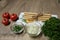 Top view bread sticks, gressini on a napkin , onions, parsley, tomatoes table