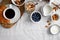 Top view of breakfast table with coffee, croissant, granola, nuts, berries and milk.