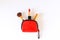 Top view of bright red make up bag with decorative cosmetic, lipstick and brush on white background.