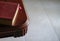 Top view of brown color cover book with pink book mark on the side of wood table