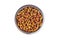 Top view of brown kibble pieces for cat feed in a metal bowl isolated on white background. Healthy dry pet food.